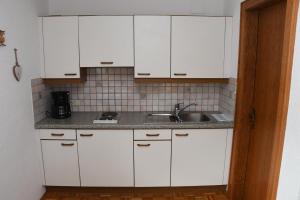HöfenFerienwohnung Dreer的厨房配有白色橱柜和水槽