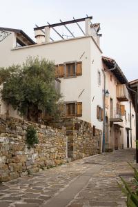 斯马尔诺Aldilà Art Rooms, Apartment and Vacation House的一条带有石墙和建筑的小巷