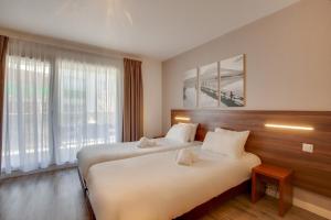 艾克斯莱班阿祖雷公寓酒店的酒店客房设有两张床和大窗户。