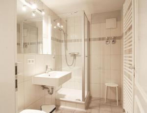 奥斯赛拜-屈隆斯博恩Appartmenthaus Villa Laura的白色的浴室设有水槽和淋浴。