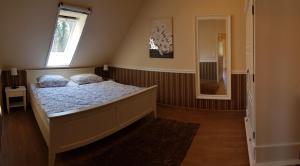 KolonieFerienwohnung Wasserlilie的一间卧室设有一张床、一个窗口和一面镜子