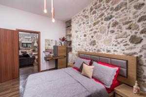 扎罗斯Zaros Villa Fountarinis的一间卧室设有石墙和一张床