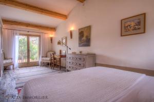 维琪奥港Villa Serenita Pallombaggia的一间卧室配有一张床、一张桌子和一个窗户。
