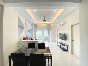 瓜埠Langkawi Simfoni Beliza Apartment with Sky Pool by Zervin的客厅设有餐桌和天花板