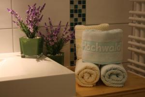 巴特利本采尔Hotel Hochwald的浴室提供毛巾和鲜花,摆放在桌子上