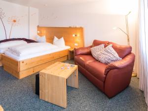 巴特利本采尔Hotel Hochwald的一间卧室配有一张床、一张沙发和一把椅子