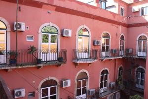 里斯本Belém Tejo - Setubalense的红色的建筑,设有窗户和阳台