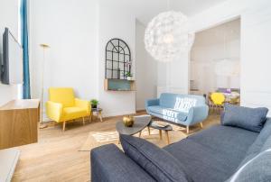 布鲁塞尔Grand Place 2 Bedroom的客厅配有蓝色的沙发和黄色的椅子