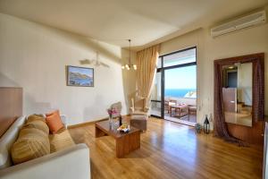 阿齐亚佩拉加Athina Palace Resort & Spa的客厅配有沙发和桌子