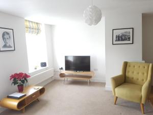 沃里克Warwick Market Place Apartment的一间带电视和椅子的客厅