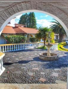 塔巴贝拉圣卡洛斯塔巴波拉酒店的石制人行道,有白色的栅栏和喷泉