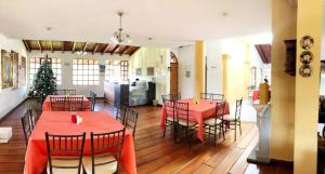 塔巴贝拉圣卡洛斯塔巴波拉酒店的用餐室配有红色的桌椅和圣诞树