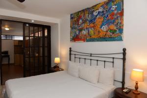 马那瓜拉波萨达德尔阿康热尔住宿加早餐旅馆的卧室配有一张床,墙上挂有绘画作品