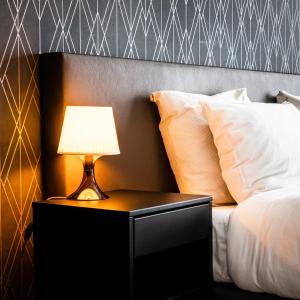 米德尔堡Hotel Brasserie de Huifkar的一张带床头柜和台灯的床