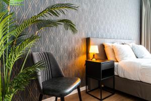 米德尔堡Hotel Brasserie de Huifkar的一间卧室配有床、椅子和植物