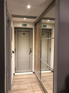 PotamósLidea Boutique Hotel的走廊上设有镜子,房间设有门