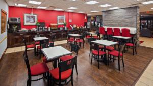 奥克福里斯特Chicago Southland Hotel的餐厅拥有红色的墙壁和桌子以及红色的椅子