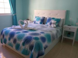 滨海帕尔姆Laderas del Palmar的一间卧室配有一张带两个天鹅的床