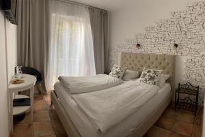 慕尼黑慕尼黑竞技场城市酒店的一间卧室设有一张带砖墙的大床