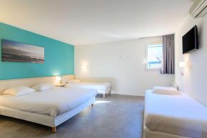 萨兰北奥尔良凯立德酒店 - 萨兰的酒店客房设有两张床和蓝色的墙壁。