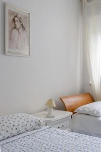 托雷苏达°la casetta d'Amare°的一间卧室配有两张床和一张墙上图片的书桌。