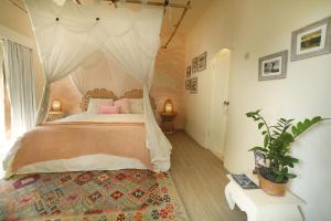 坎古The Chillhouse Canggu by BVR Bali Holiday Rentals的卧室配有带粉红色枕头的天蓬床