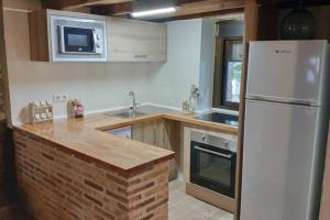 厄尔巴拉克Casa en La Rinconada的厨房配有白色冰箱和水槽