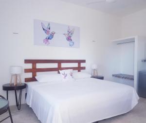 奥尔沃克斯岛Casa Chujuk by Spirit Group的卧室配有一张白色床,墙上有2只鸟