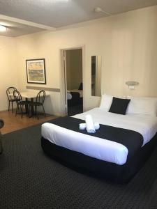 阿德莱德Bay Motel Hotel的酒店客房设有一张大床和一张桌子。