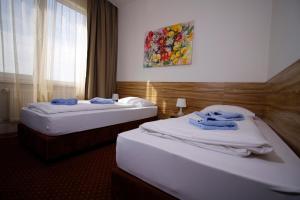布拉迪斯拉发布拉迪斯拉发加尼飞行员酒店的两张位于酒店客房的床,配有毛巾