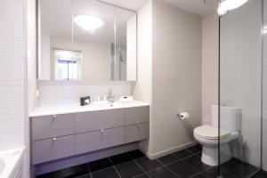 墨尔本AKOM AT Docklands的白色的浴室设有水槽和卫生间。
