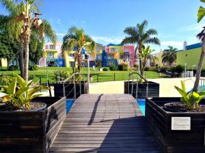 阿尔布费拉Marina de Albufeira Orada Resort - 2-bed apartment with huge pool的棕榈树木板路和房屋的背景