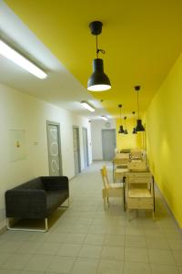 克罗梅日什Hostel U Zlatého kohouta的一间设有桌子、沙发和黄色墙壁的客房