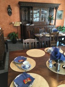 爱尔福特温格里奇膳食公寓的一间带桌椅和蓝色餐巾的用餐室