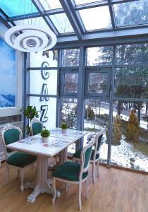 普雷代亚尔Park Luxury Rooms的一间带桌椅和窗户的用餐室