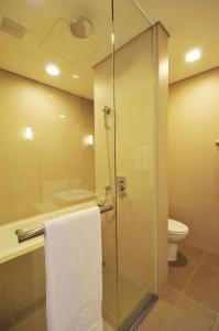 台南Academy Hotel的一间带玻璃淋浴和卫生间的浴室