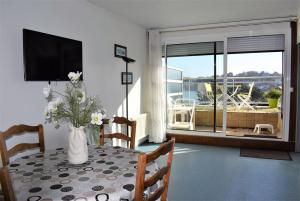 佩罗斯-吉雷克Appartement 2-4 pers VUE MER EXCEPTIONNELLE avec terrasse à PERROS-GUIREC - Ref 908的一间房间,桌子上放着花瓶