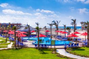 马特鲁港波尔图玛特鲁海滩度假酒店的一个带红伞和海滩的度假游泳池