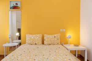 雅典So Athens - Charming 1BD flat, Large terrace, Acropolis view的一间卧室配有一张黄色墙壁的床