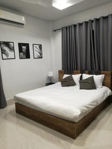 勿洞Betong Cozy Guesthouse เบตง โคซี่ เกสต์เฮาส์的一间卧室配有一张带白色床单的大床