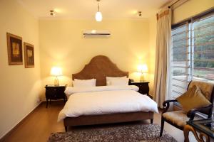拉瓦尔品第Butterfly Guest House Phase 7 Bahria Town的卧室配有床、椅子和窗户。