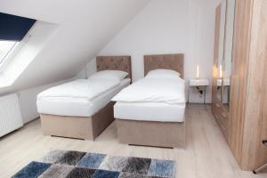 杜伊斯堡T&K Apartments near Messe Fair Trade Düsseldorf und Airport 3A的阁楼卧室设有两张床,铺着地毯。