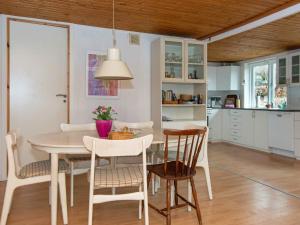 格莱斯堡6 person holiday home in Glesborg的厨房以及带桌椅的用餐室。
