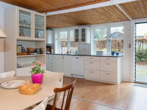 格莱斯堡6 person holiday home in Glesborg的厨房配有白色橱柜和桌子