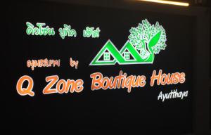 大城Q Zone Boutique House的带有 ⁇ 虹灯标志的区反弹房屋标志