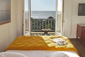 维莱尔维尔贝尔维尤酒店的一间卧室设有一张床,享有海景