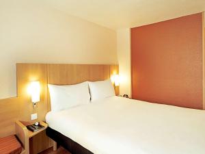 里斯本宜必思里斯本荷西玛尔禾酒店的卧室配有带白色枕头的大床