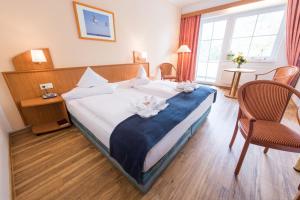 格拉尔-米里茨Hotel Ostseewoge的酒店客房配有一张带蓝色毯子的大床