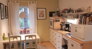 柏林花园民宿的厨房配有桌子和白色冰箱。