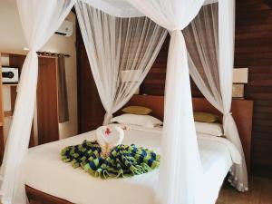 蓝梦岛达尔桑蓝梦精品小屋旅馆的卧室配有2张带白色窗帘的床